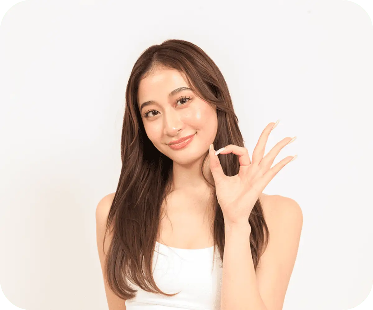 顔の横に指でokサインを作っている女性の画像