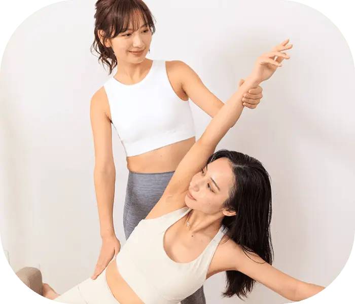 補助を受けながら女性がストレッチをしている画像