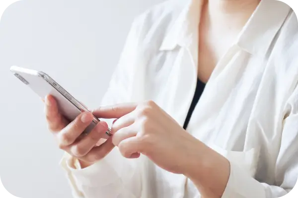 女性がスマートフォンを操作している手元の画像