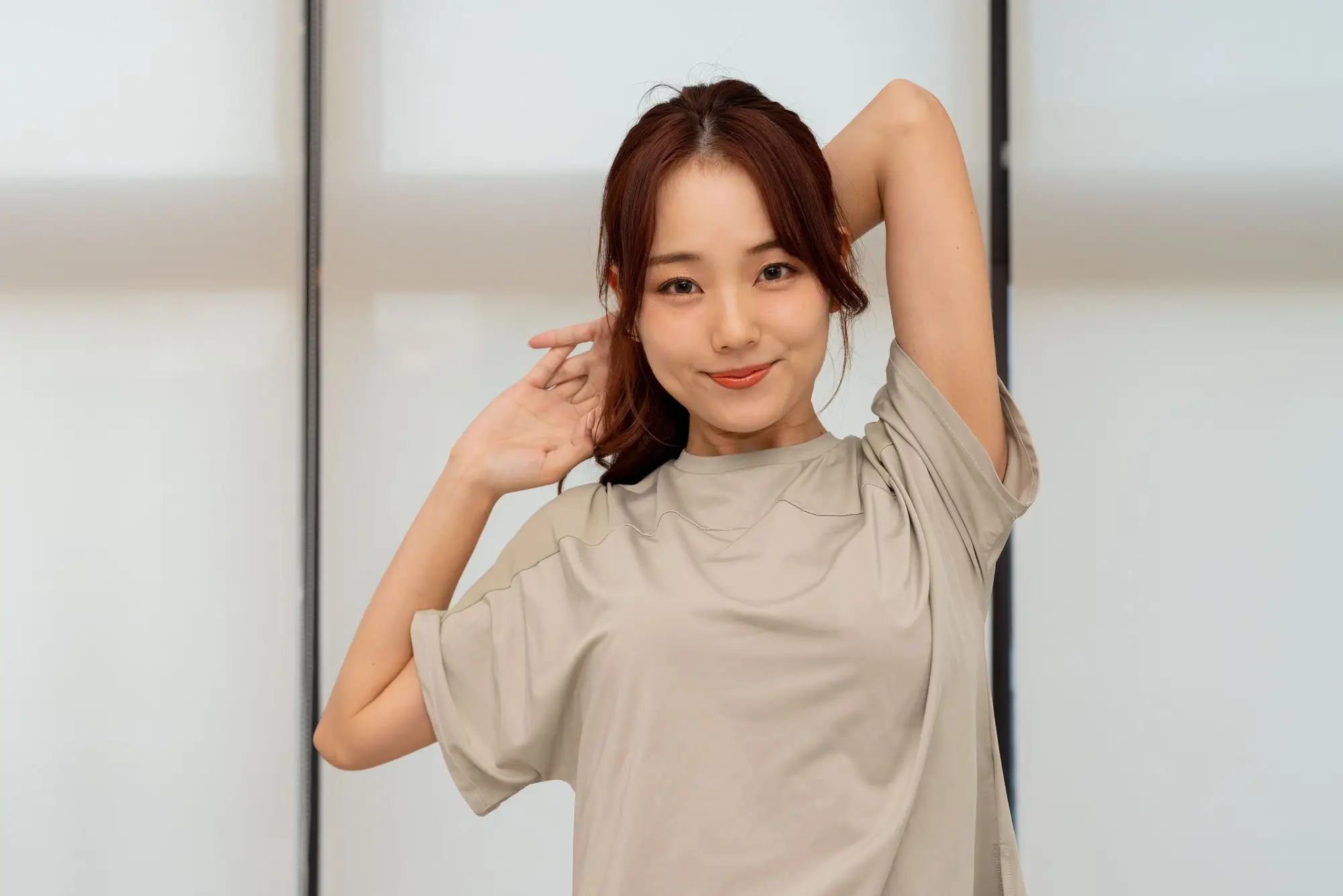 腕を体の後ろに持っていきストレッチをしている女性の画像